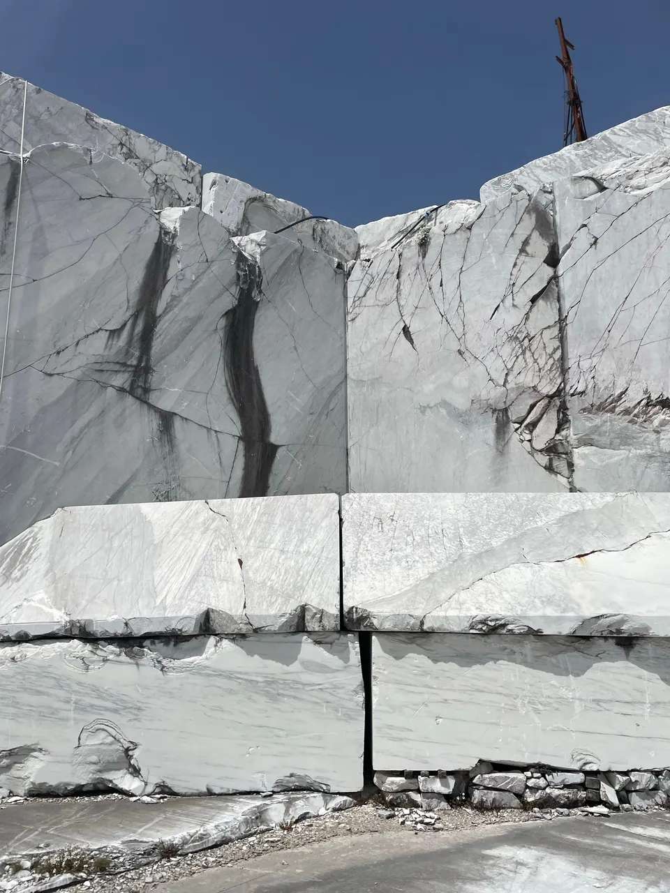 White marble blocks in an open quarry under a blue sky